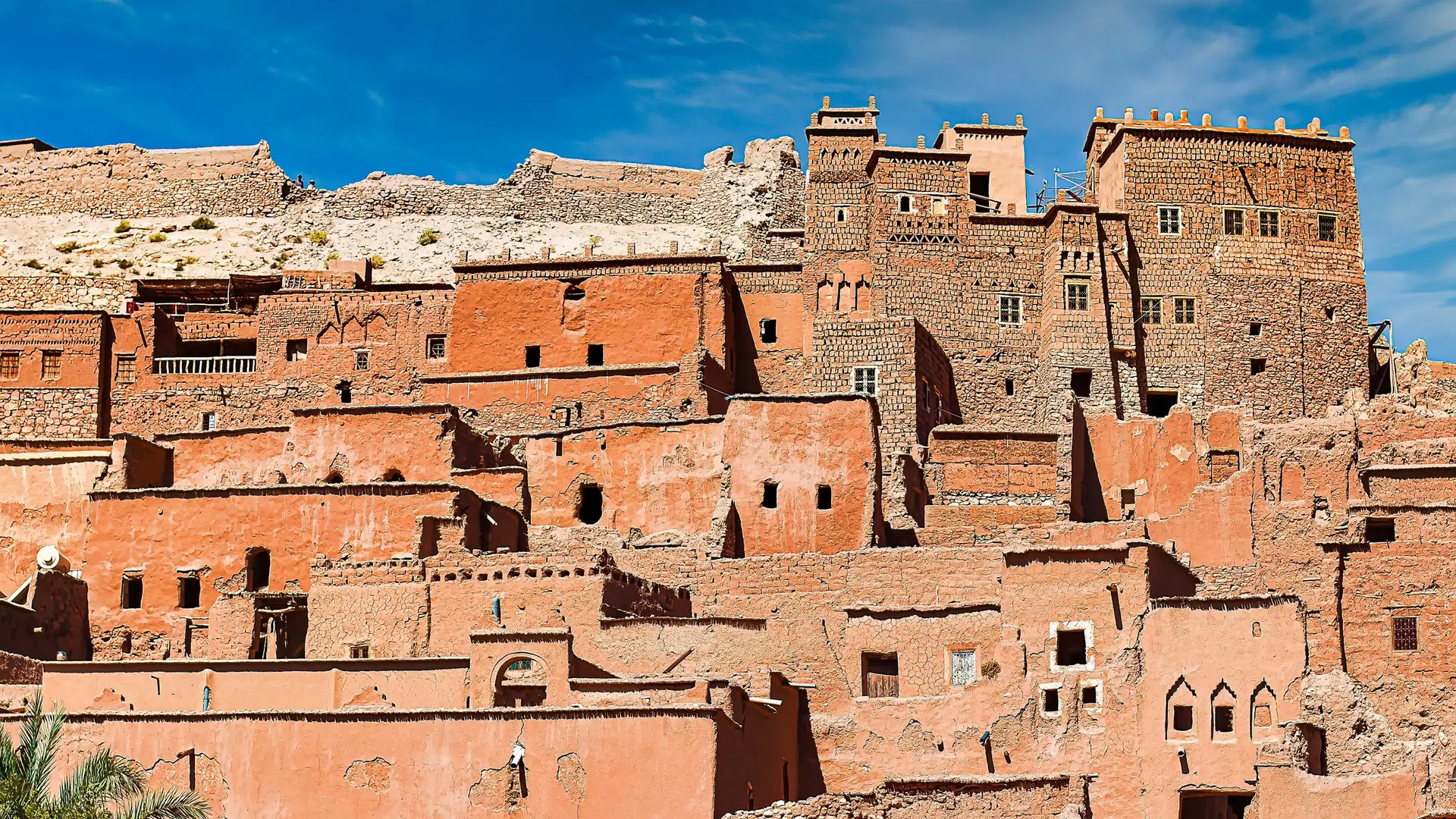 Earth-built towers of the ksar of Aït Benhaddou under a blue sky